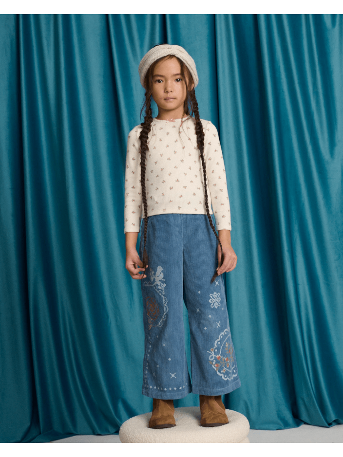 Drusilla Tee with Ruffled Shoulders and Cross-Stitched Flower Appliqué with Lace Trims